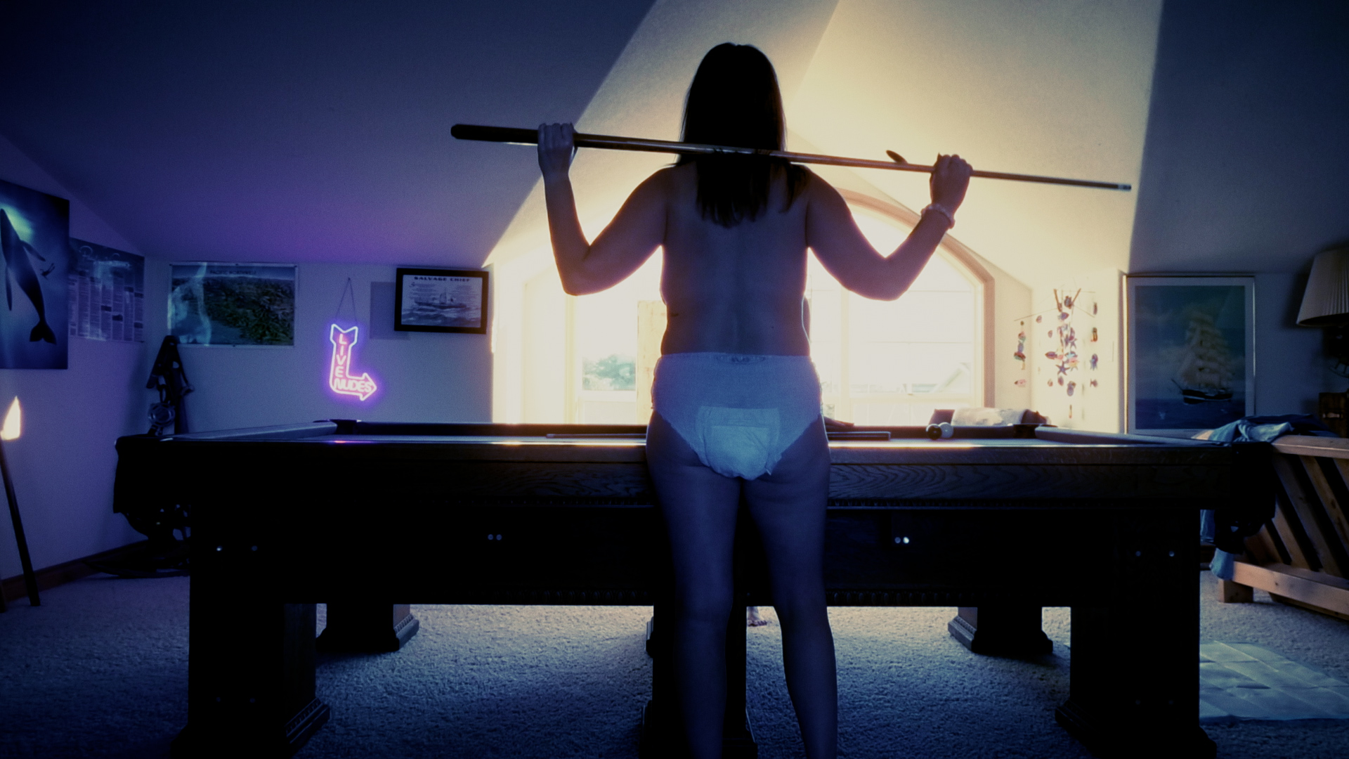 Rear view of Alisha playing pool while wearing only a diaper.